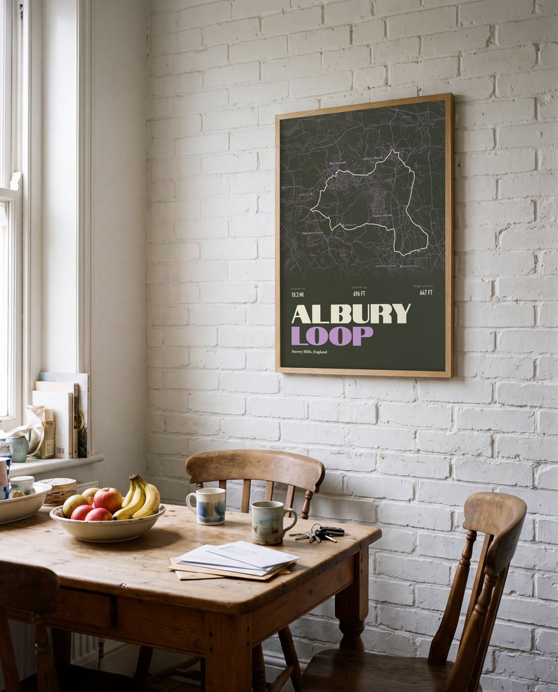 A Albury Loop walking print in Black Olive, in a natural wood frame, on a white-brick kitchen wall
